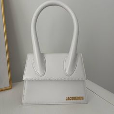 *Real* Currently Selling For $900 On Their Website White Le Chiquito Moyen Jacquemus Bag Includes Dust Bag And Shoulder Strap I Do Not Have The Box Included Email I Received When Purchased From Jacquemus Website I Only Wore It One Time No Stains Or Damage Brand New Condition Will Accept Offers Close To Asking Price Jacquemus Chiquito, Le Chiquito Moyen, Jacquemus Bags, Jacquemus Bag, Woven Raffia, Distressed Black Jeans, Shop Wallpaper, Crate And Barrel, White Leather