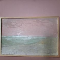 a painting hanging on the wall next to a framed piece of art with an ocean scene painted on it