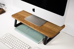 an apple computer sitting on top of a wooden desk