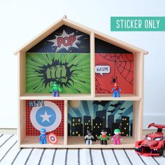 a toy house with stickers on the front and sides, next to other toys