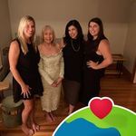 four women are posing for a photo in front of a heart - shaped sticker