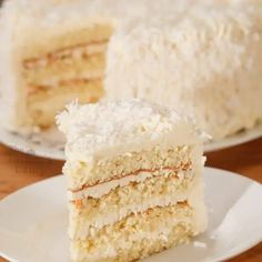 two slices of coconut cake on white plates