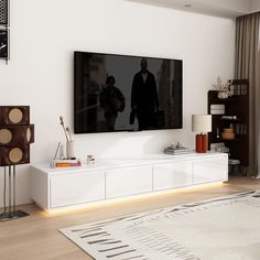 a flat screen tv sitting on top of a white entertainment center in a living room