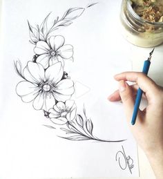 a person is drawing flowers on a piece of paper