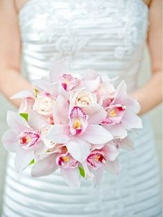 a bride holding a bouquet of pink and white flowers