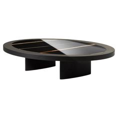 an oval table with black and gold stripes on the top, in front of a white background