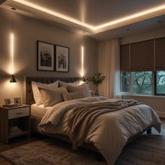 a large bed sitting in a bedroom next to a window with lights on the side