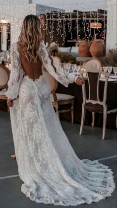 the back of a woman's wedding dress, with long sleeves and open shoulders