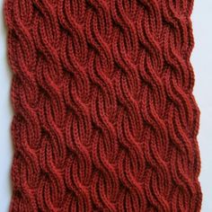 a red knitted scarf on a white surface