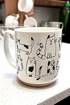 Celebrate your love for felines with this charming ceramic cat mug, featuring hand-drawn doodles of quirky cats with playful expressions. Its speckled finish gives a handmade, artisanal feel, while the large capacity and sturdy handle make it perfect for coffee, tea, or any drink. Microwave and dishwasher-safe, this mug is both practical and delightful. A perfect gift for cat enthusiasts or a treat to brighten your day.