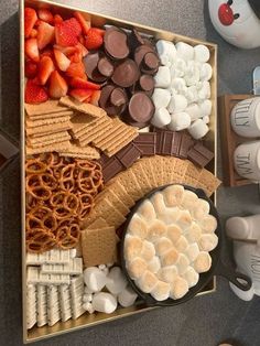 a box filled with marshmallows, pretzels, and other snacks