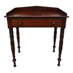 an antique wooden desk with turned legs