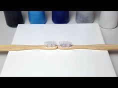 two toothbrushes sitting on top of a white table