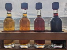 four bottles of alcohol lined up on a window sill