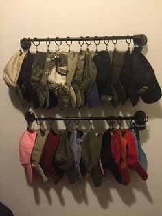 there is a rack with hats hanging on the wall next to a pair of shoes