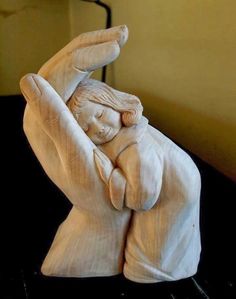 a statue of a person holding their hands together