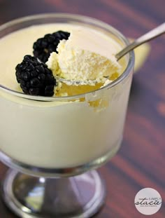 a dessert in a glass bowl with blackberries on top