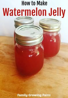 three jars filled with red liquid sitting on top of a wooden table