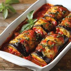 eggplant stuffed with marinara sauce in a white casserole dish on a wooden table