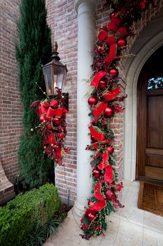 a red christmas garland hanging on the side of a building