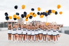 a group of cheerleaders holding up pom - poms in the air