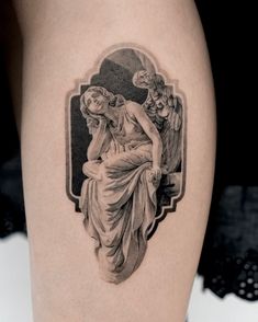 a woman's leg with a tattoo on it that has an image of a seated woman