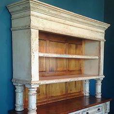 an old dresser is painted blue and has white paint on the top with wood trimmings