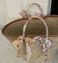 an empty basket sitting on the floor next to a door with ribbon tied around it