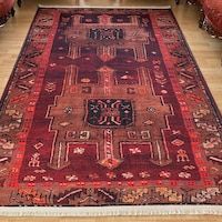 an antique rug is on the floor in a room with wooden floors and red couches