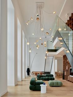 a living room filled with lots of furniture next to a stair case and glass railing