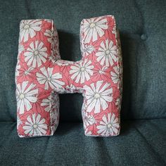 the letter h is made out of fabric and has flowers all over it's sides