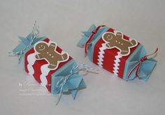 two red and blue gift boxes with gingerbread cookies on them, tied in twine