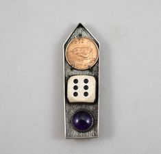 a metal object with two dices and a penny in it's back end