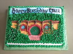 a birthday cake that is decorated with green frosting and an image of a hobbot house