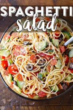 spaghetti salad with tomatoes, cucumbers, and olives in a glass bowl