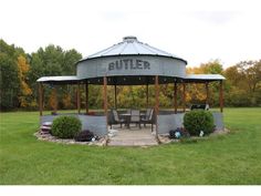 a round metal structure with tables and chairs under it