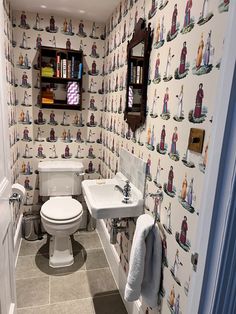 a bathroom with a toilet, sink, and mirror in it's wallpaper