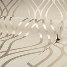 a roll of white wallpaper with an intricate design on the wall and it's shadow