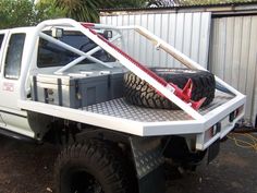 a white truck with two large tires on the back