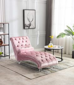 a pink chaise lounge chair sitting on top of a rug in a living room