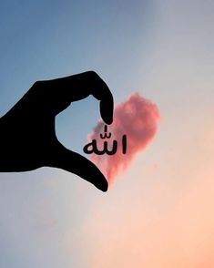 a hand is holding up the word i love you in front of a pink cloud