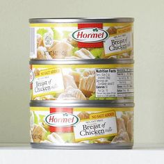 three cans of food sitting on top of a counter