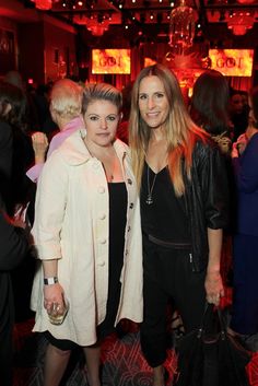 two women standing next to each other at a party