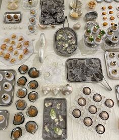 a table topped with lots of trays filled with desserts and muffins