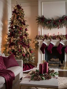 a living room with a christmas tree decorated in red and gold stockings, candles and decorations