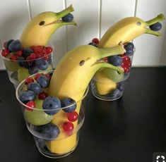 two glasses filled with fruit and bananas sitting on top of a black table next to the words bona nit