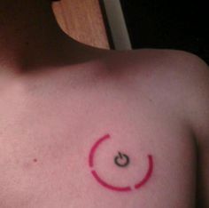 a close up of a person's chest with a smiley face tattoo on it