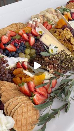 an assortment of fruits and cheeses on a platter