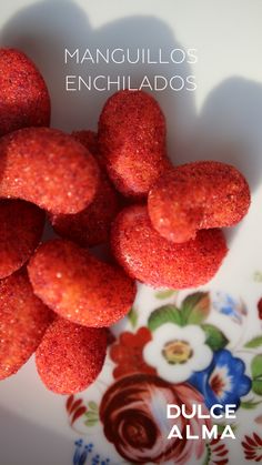 there are many red donuts on the plate with words above them that read, manquillos enchilados