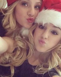 two beautiful young women wearing santa hats